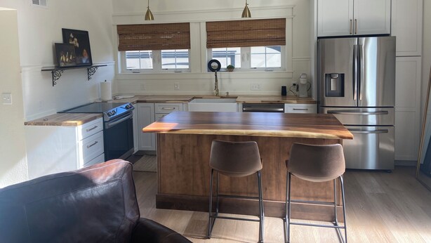 A modern kitchen with a central island, stainless steel appliances, and pendant lighting.