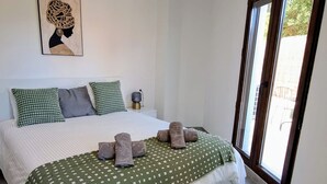 A bedroom with a bed, pillows, a blanket, and a wall art piece. - Happy Travel La Maestranza 5A (Marbella)
