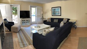 A living room with a sofa, a TV, and a dining area with a table and chairs. - Spacious 4-bedroom house in enjoyable Dewey Beach with WiFi, AC (Dewey Beach)