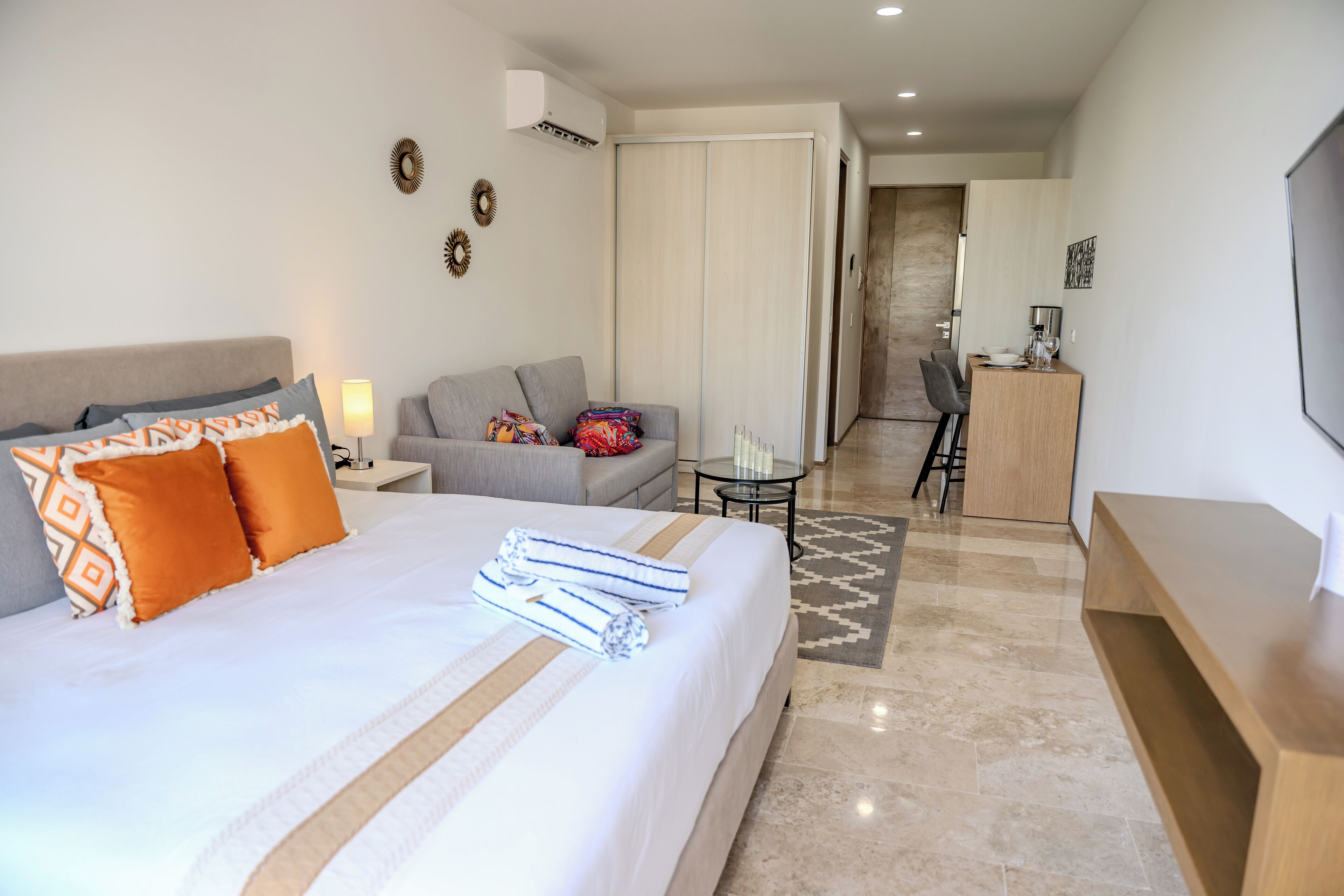 Une chambre d’hôtel avec un lit, un canapé, un bureau et une télévision.