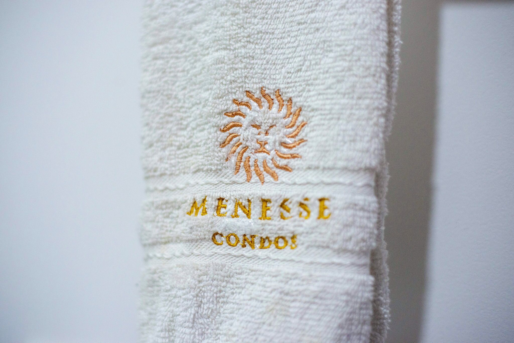 Una toalla con bordado que dice "MENESSE CONDOS".