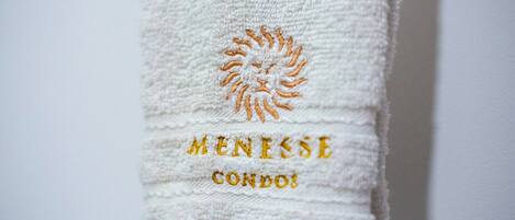 Una toalla con bordado que dice "MENESSE CONDOS".