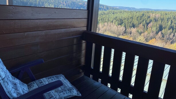 A wooden deck with a bench and a newspaper. - Complete Apartment With own Balcony (Vohenstrauss)