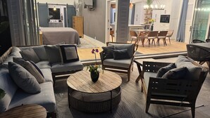 Una sala moderna con un conjunto de sofás, una mesa de centro y una zona de comedor con sillas y una mesa.