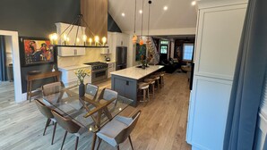 Una cocina moderna con una isla central, electrodomésticos de acero inoxidable e iluminación colgante.