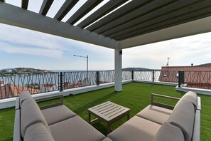 Enjoy the breathtaking view from this rooftop terrace with a shaded seating area and comfortable lounge chairs.