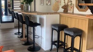 Eine moderne Küche mit Holzhocker, einer Treppe und einem Essbereich mit einer Couch.