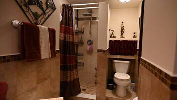 A bathroom with a shower, toilet, and sink.