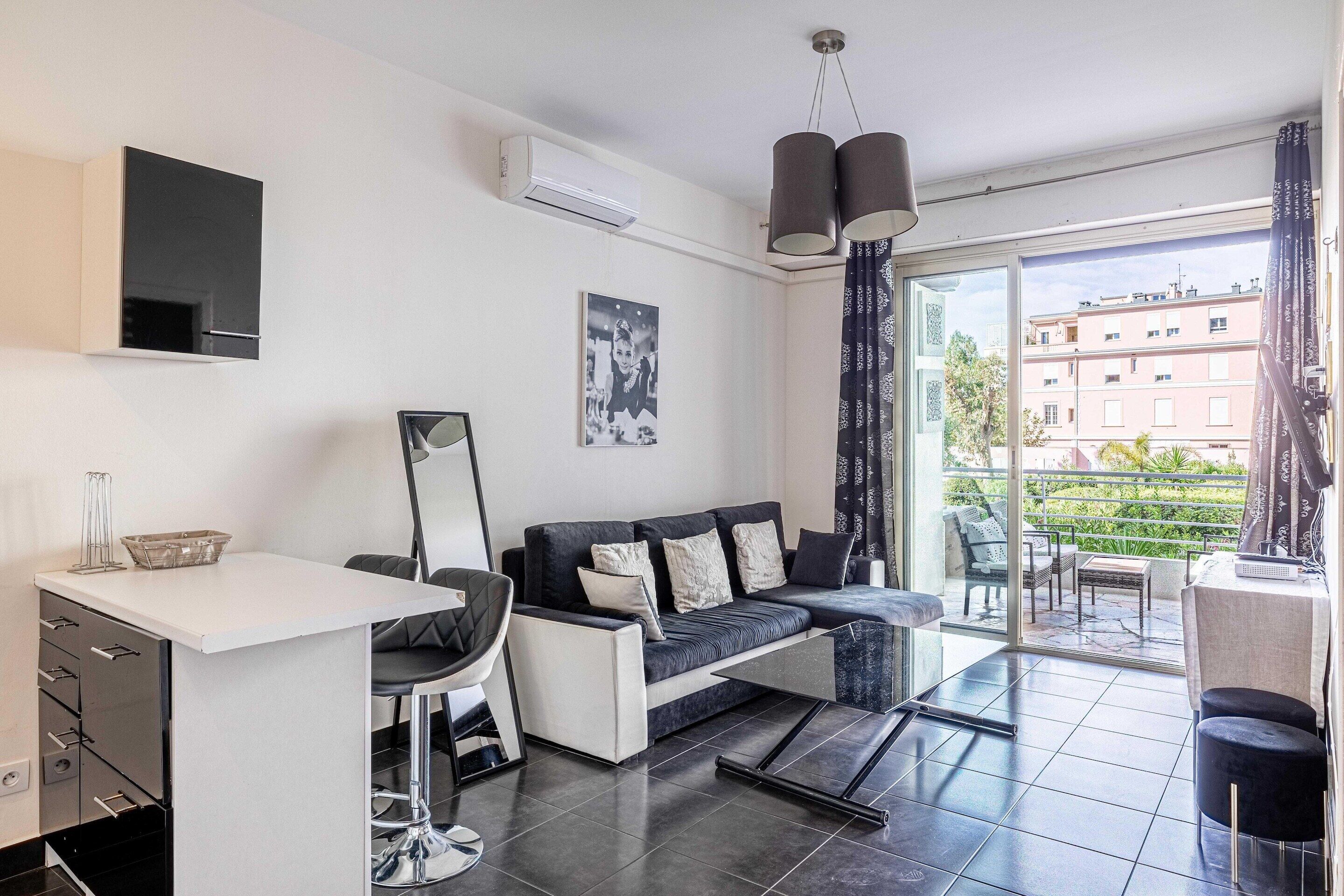 A modern living room with a sofa, a dining table, and a TV.