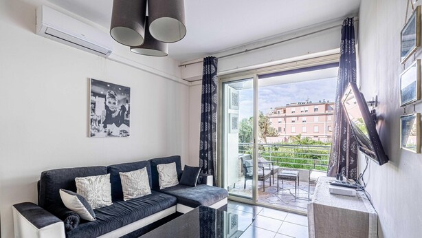 Een moderne woonkamer met een bank, een bijzettafeltje en een schuifdeur naar een terras.