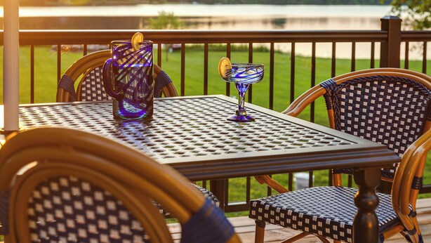 A deck with a table and chairs, overlooking a lake. - Wonderland: Waterfront + Game Room + Dog Friendly (Albion)