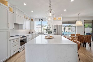 A modern kitchen with white cabinetry, a large island, and a view of the outdoors. - Scottsdale Getaway- Luxury Home, 5-Star Location, Golf, Shop, Hike, Restaurants (Scottsdale)