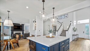 A spacious kitchen with a large island, wooden flooring, and modern pendant lighting. - Scottsdale Getaway- Luxury Home, 5-Star Location, Golf, Shop, Hike, Restaurants (Scottsdale)