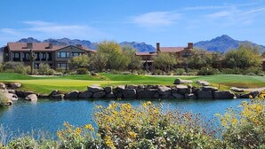 A golf course with a pond, surrounded by houses and mountains. - Scottsdale Getaway- Luxury Home, 5-Star Location, Golf, Shop, Hike, Restaurants (Scottsdale)