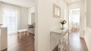 A modern, well-lit living room with a glass coffee table, a sofa, and a dining area with chairs. - D&S - Torne Apartments II (Vila Nova de Gaia)