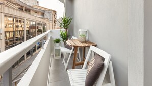 A balcony with white chairs, a small table, and potted plants. - D&S - Torne Apartments II (Vila Nova de Gaia)
