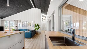A modern kitchen with a wooden countertop, a built-in sink, and a large window. - Gorgeous home in Knebel with sauna (Knebel)