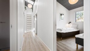 A modern bedroom with a bed, bedside table, and a window. - Gorgeous home in Knebel with sauna (Knebel)