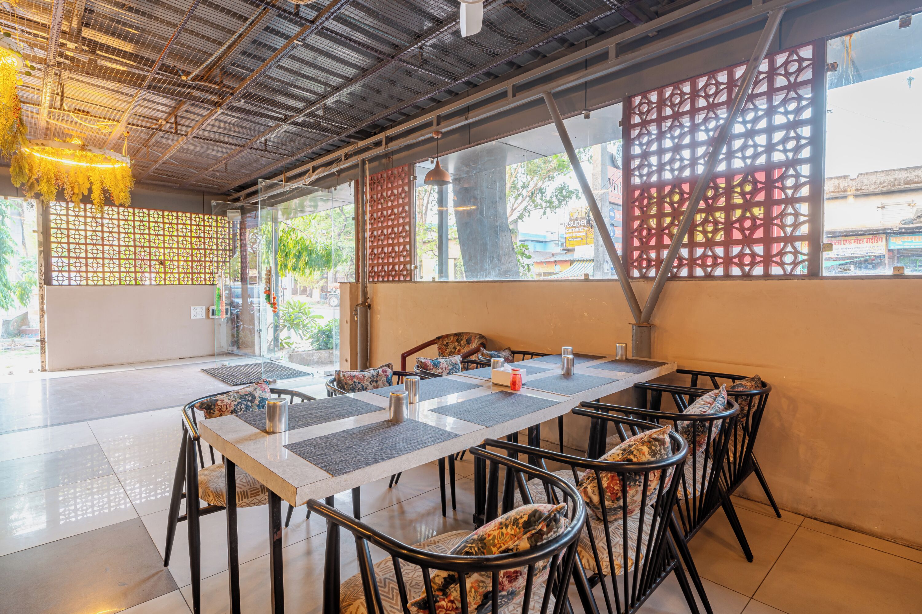 Un restaurante con una larga mesa, sillas y un techo decorativo.