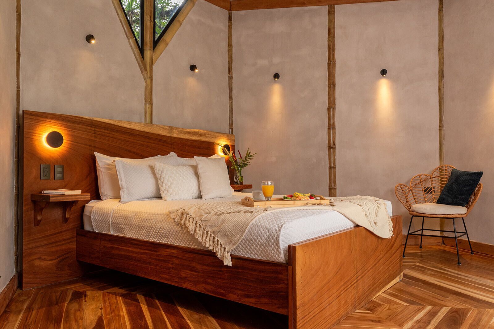 A wooden bed with a headboard, bedside tables, and a tray with breakfast items.