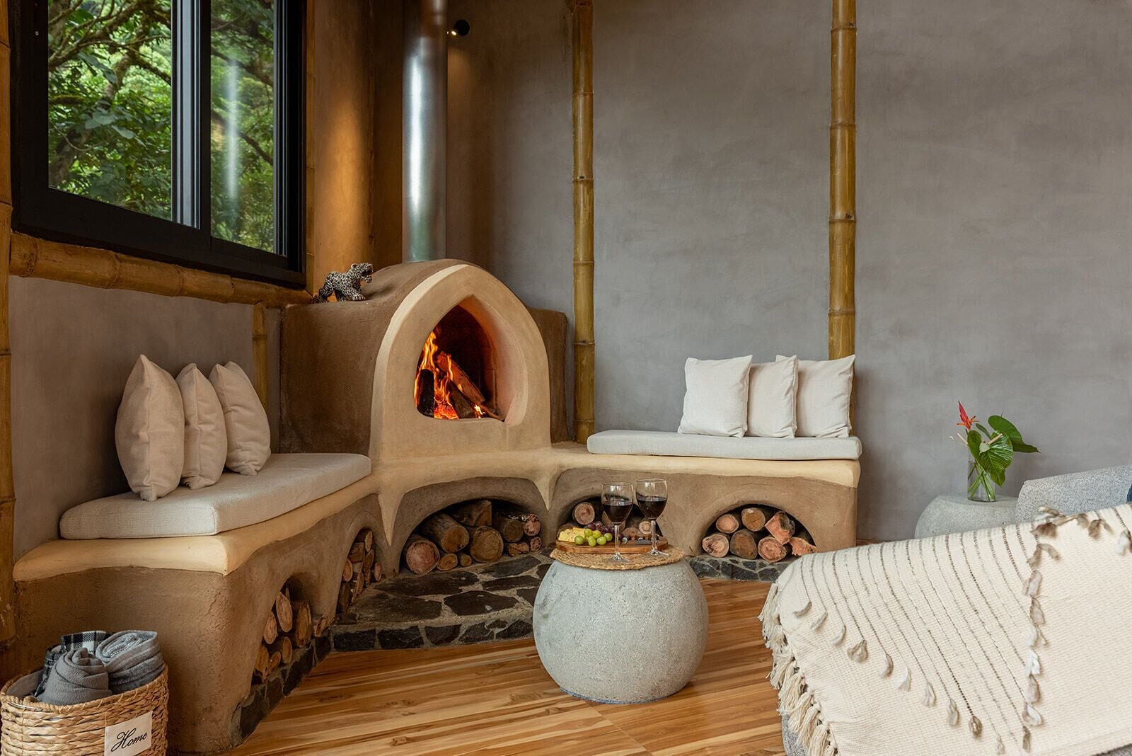 Une pièce chaleureuse avec une cheminée en pierre, un banc rembourré et un plancher en bois.