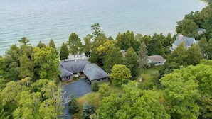 Une propriété au bord du lac, comprenant plusieurs maisons entourées d’une forêt dense, et offrant une vue sur le lac.