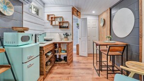 A compact kitchen with a vintage teal refrigerator, wooden cabinets, and a dining area with a wooden table and chairs. - Peaceful Lake View Retreat Near Parks 10 Minutes to Downtown (Orlando)