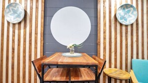 A wooden dining table with a white circular backdrop, flanked by vertical wooden slats and two decorative plates. - Peaceful Lake View Retreat Near Parks 10 Minutes to Downtown (Orlando)