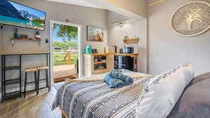 A bedroom with a bed, a TV, a desk, and a view of the outdoors. - Lake view + 10min to dwtn + near parks + 2 guests! (Orlando)