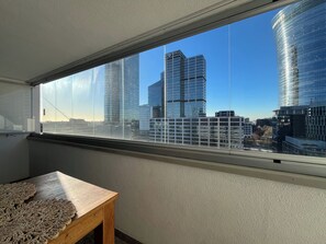 A room with a large window overlooking a cityscape with modern skyscrapers. - 2 Bedrooms Apartment, Central Warsaw (Warsaw)