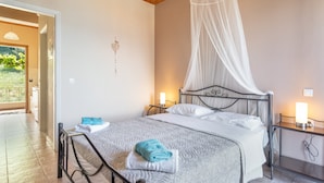 A bedroom with a bed, bedside tables, a canopy, and a view of the outdoors. - Studio Apartment 'Two Adults No 1' with Sea View, Wi-Fi and Air Conditioning (Nikiana)