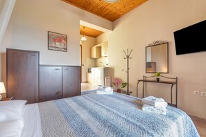 A bedroom with a bed, a wardrobe, a television, and a mirror. - Studio Apartment 'Two Adults No 2' with Sea View, Wi-Fi and Air Conditioning (Nikiana)