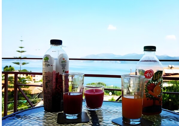 A table with drinks and a bottle, overlooking a scenic view.