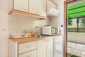 A kitchen with white cabinets, a microwave, a sink, and a dishwasher. - Studio Apartment '3 Adults No 3' with Sea View, Wi-Fi and Air Conditioning (Nikiana)