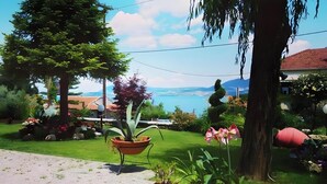 A garden with a potted plant, a lawn, and a view of a body of water. - Studio Apartment '3 Adults No 4' with Sea View, Wi-Fi and Air Conditioning (Nikiana)