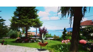A garden with a potted plant, a lawn, and a view of a body of water. - Studio Apartment '3 Adults No 5' with Sea View, Wi-Fi and Air Conditioning (Nikiana)