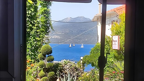 A view of a coastal area with boats, greenery, and a mountain in the background. - Studio Apartment '3 Adults No 5' with Sea View, Wi-Fi and Air Conditioning (Nikiana)