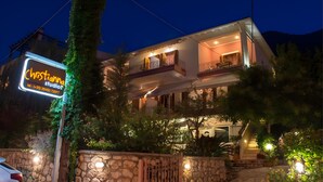 A two-story house with a balcony, a stone wall, and a sign for 'Christiana Studios.' - Studio Apartment '3 Adults No 5' with Sea View, Wi-Fi and Air Conditioning (Nikiana)