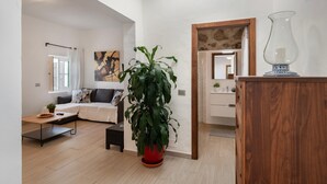 Una sala de estar moderna con un sofá, una mesa de centro, una planta en maceta y un aparador de madera.