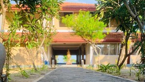 A stone pathway leading to a building with a red roof and a statue in the center. - Dinuda Villas Kalpitiya  (Kalpitiya)