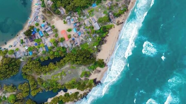 An aerial view of a coastal area with a beach, dense vegetation, and scattered buildings. - Dinuda Villas Kalpitiya  (Kalpitiya)