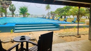A covered outdoor area with a pool, lounge chairs, and a table. - Dinuda Villas Kalpitiya  (Kalpitiya)
