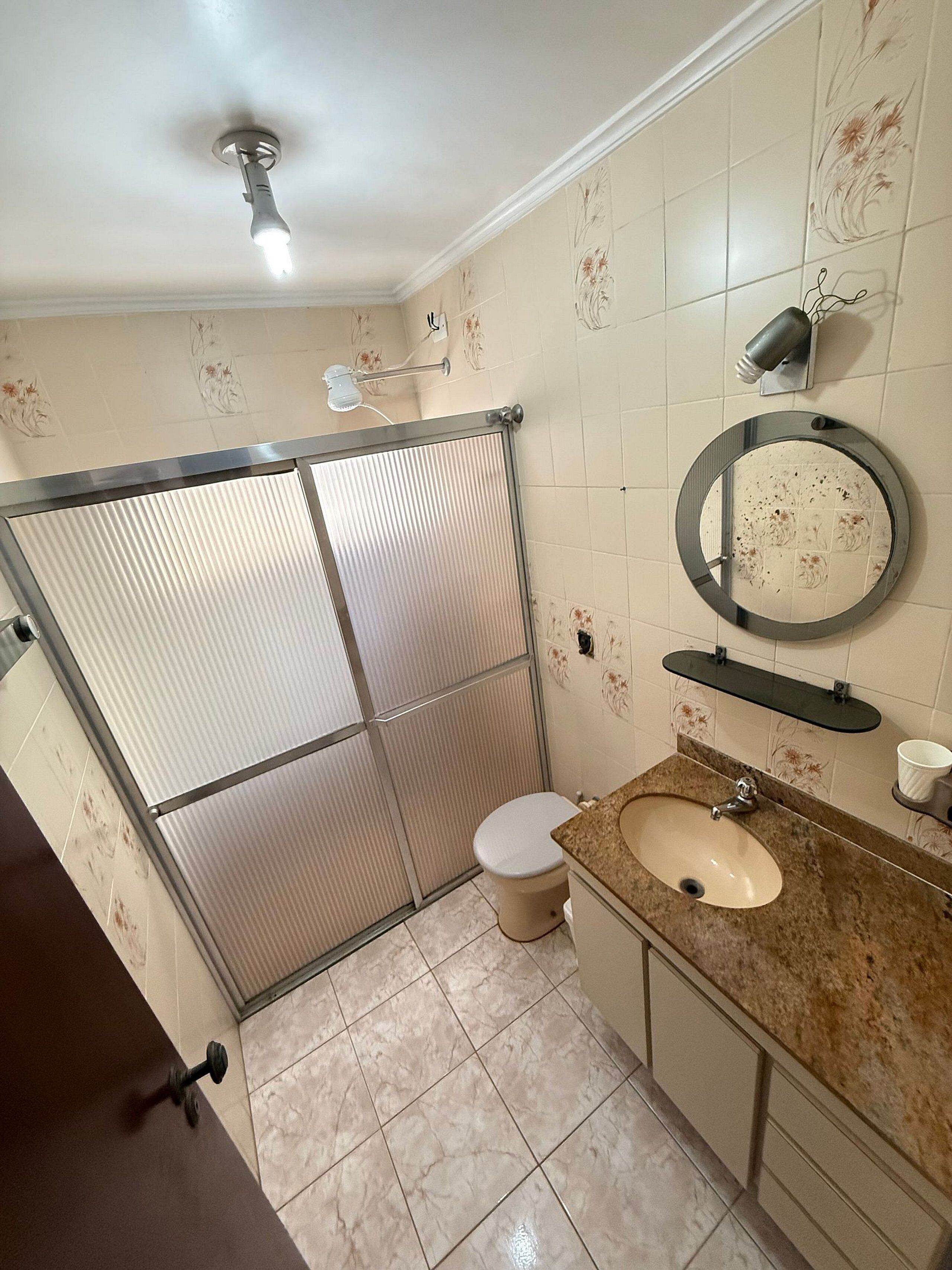 Een badkamer met toilet, wastafel en douche.