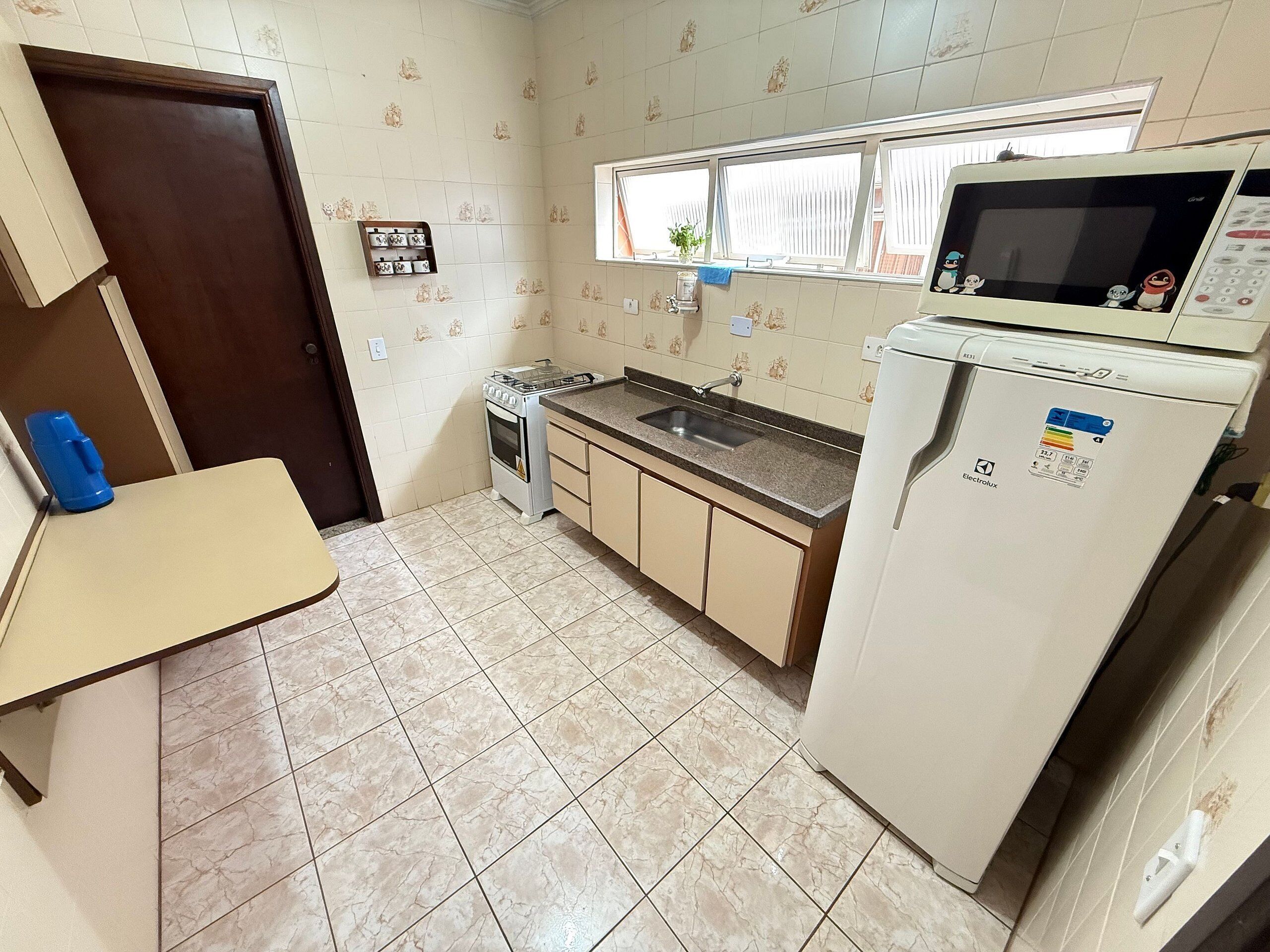 Una cocina compacta con estufa, lavabo y refrigerador.