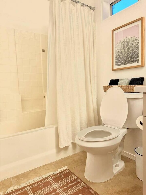 Ein Badezimmer mit Toilette, Dusche und Badewanne.