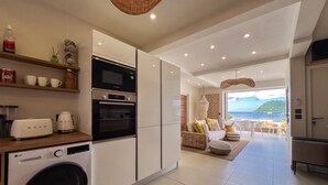 Una cocina moderna con electrodomésticos integrados, un comedor con vistas al mar y una zona de estar acogedora.