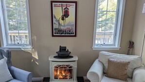 Ein gemütliches Wohnzimmer mit einem weißen Kamin, zwei Sofas und einem Bild an der Wand.