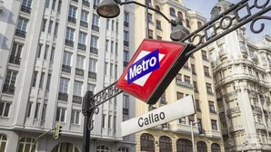 A Metro station sign with a street name sign below it. - Hostal Ruano (Madrid)