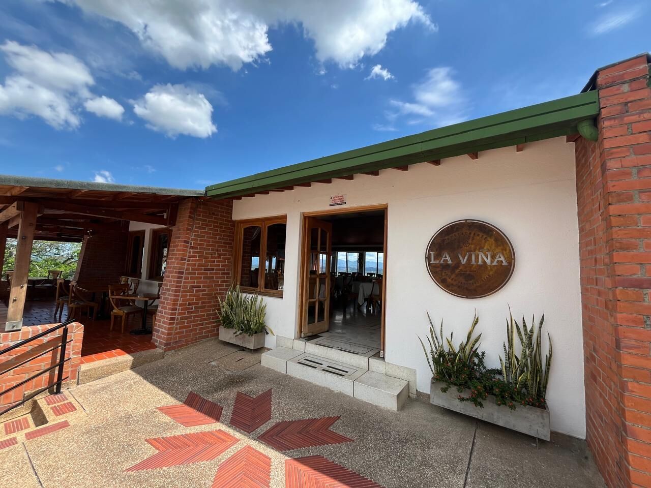 A building with a sign reading "LA VINA" and a patio area with outdoor seating.