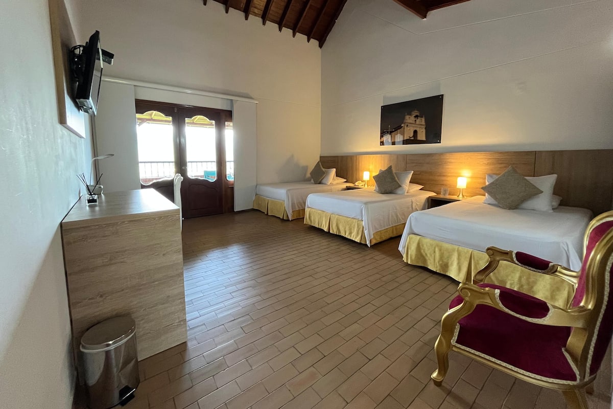 Une chambre d’hôtel avec deux lits, un bureau, une chaise et une poubelle.